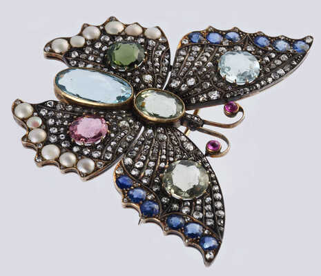 Брошь из желтого и белого металла, общим весом 24,0 грамма, содержит природные вставки